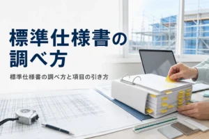 標準仕様書の調べ方を紹介する記事のアイキャッチ。現場事務所の机に置かれた付箋だらけの仕様書と図面