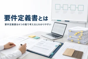 要件定義書とは何かを解説する記事のアイキャッチ。オフィスの机に広げた要件定義書とノートPC